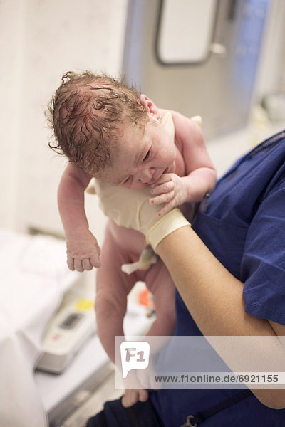 Krankenschwester hält Neugeborenen Baby