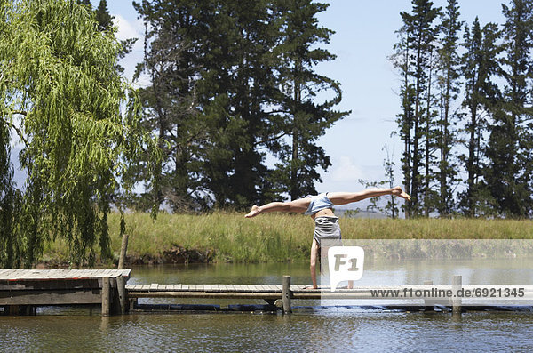 Woman Doing Handstand on Dock