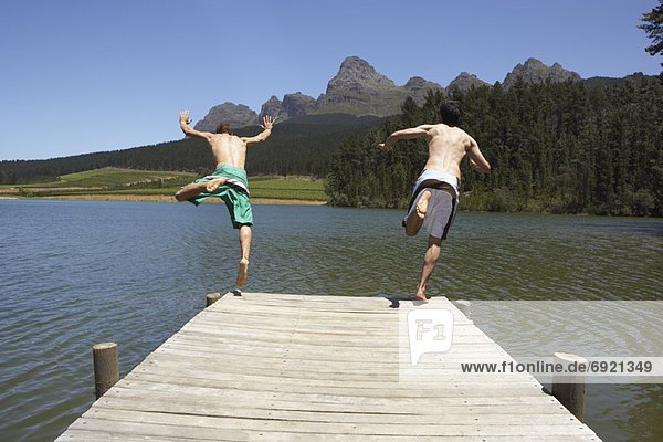 Men Jumping into Water from Dock