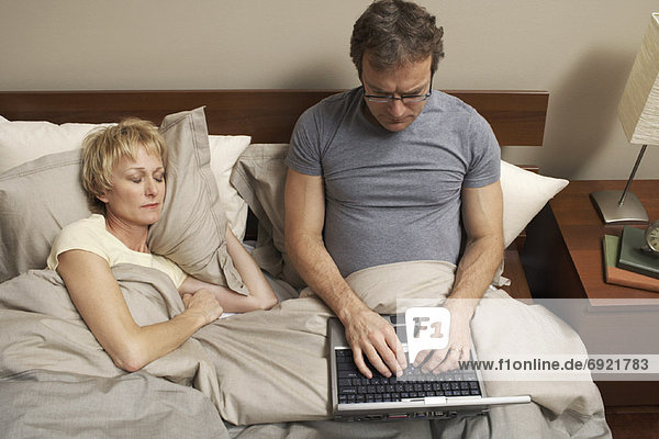 Couple with Laptop in Bed
