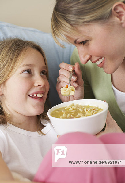 Mother and Daughter Eating Chicken Soup