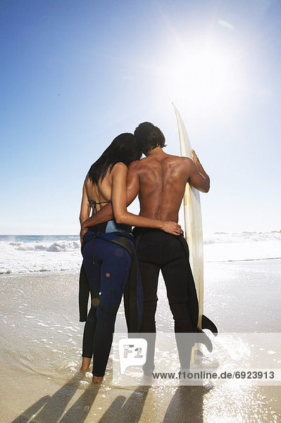 Couple with Surfboard at Beach