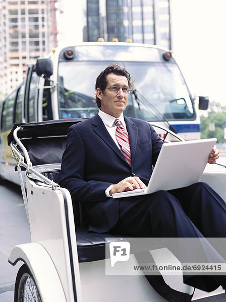 Businessman With Laptop Computer  Sitting in Rickshaw