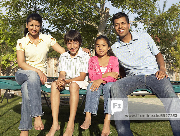 Family Sitting on Trampoline