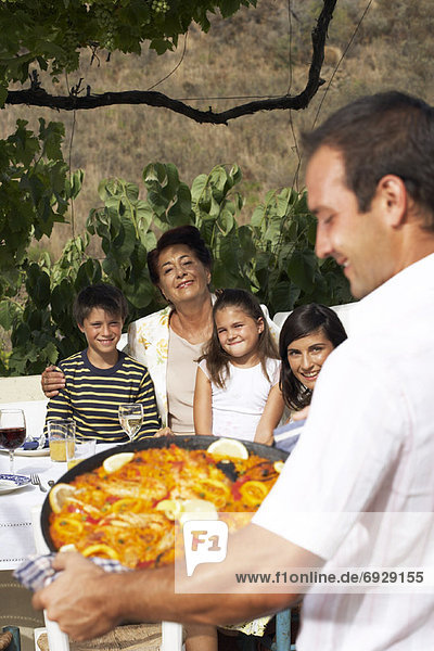 Man Serving Family Meal Outdoors