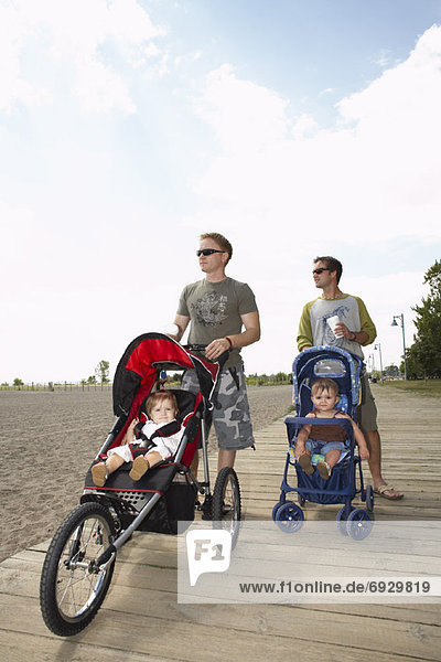 Fathers with Babies in Strollers Walking Along Boardwalk