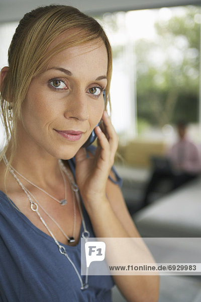 Woman Using Cellular Phone  Man in Background