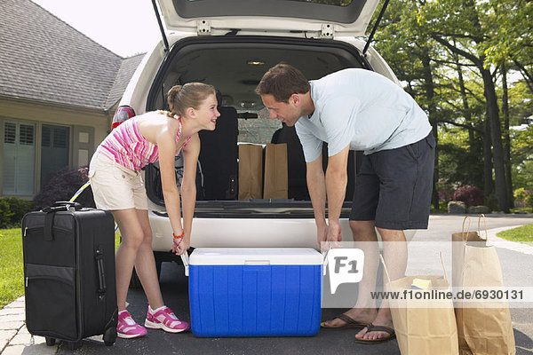 Father and Daughter Loading Minivan