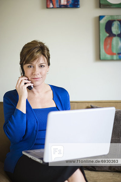 Businesswoman with Cellular Phone and Laptop Computer