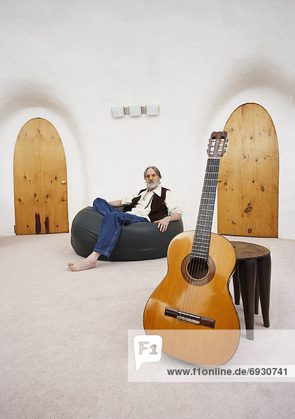 sitzend Mann Stuhl Tasche Gitarre Fokus auf den Vordergrund Fokus auf dem Vordergrund Bohne