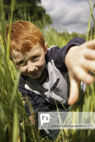 Portrait  Junge - Person  aufspüren  lang  langes  langer  lange  Gras  nachsehen