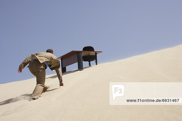 Schreibtisch Geschäftsmann Sand Büro Düne klettern