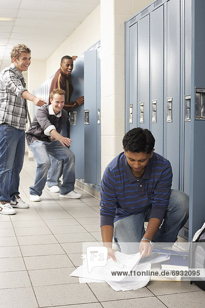 Friends Laughing at Boy Dropping Notes by Locker