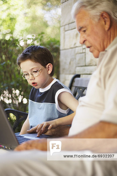 Grandfather and Grandson Looking at Laptop Computer