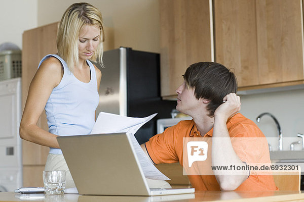 Couple in Kitchen with Laptop Computer
