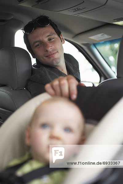 Father Looking Back at Baby in Vehicle