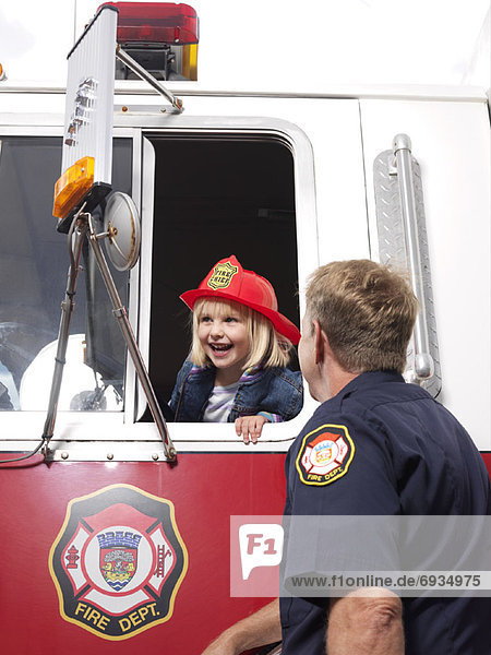 Man Looking at Girl in Fire Truck