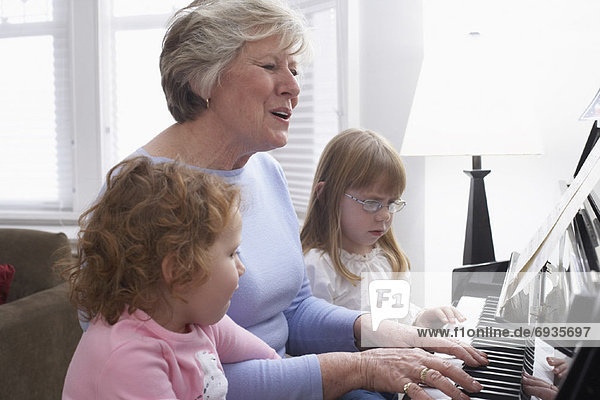 Frau  Enkeltochter  Klavier  spielen