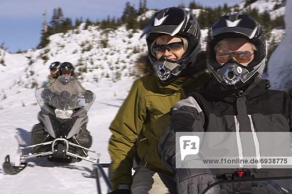 People Snowmobiling