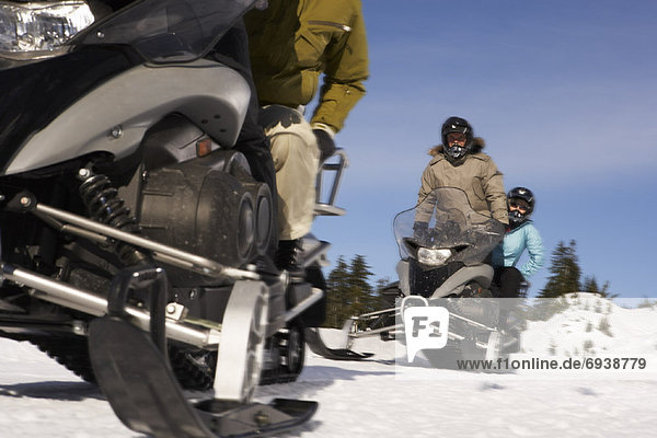 People Snowmobiling