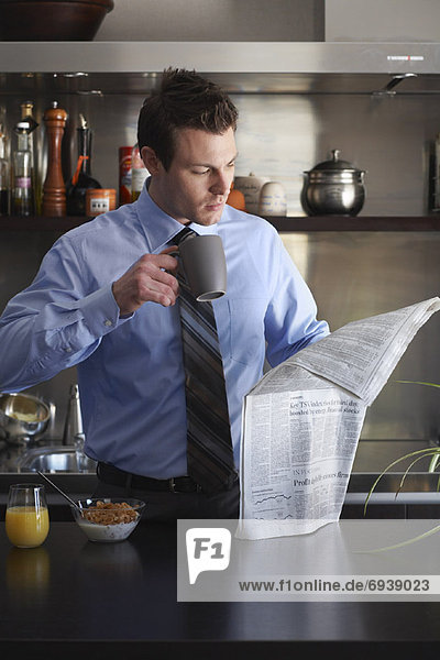 Businessman Eating Breakfast  Reading Newspaper