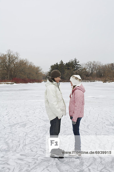 Couple Looking at Each Other on Ice Rink