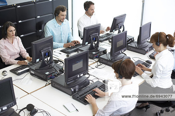Business People Working on Computers with Headsets