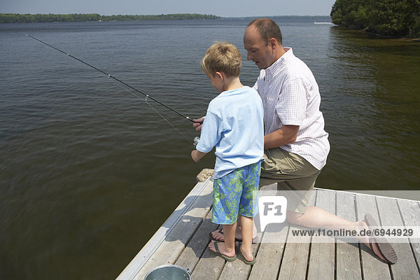Father and Son Fishing from Dock