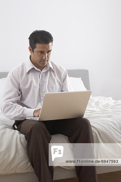 Man with Laptop on Bed