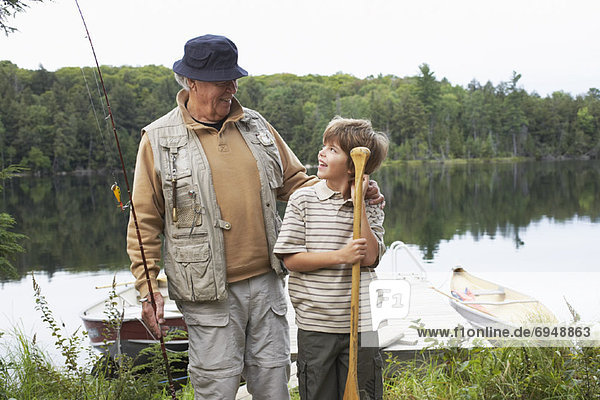 Man and Boy by Lake with Fishing Gear