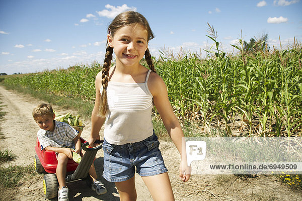 Girl and Boy with Corn and Wagon