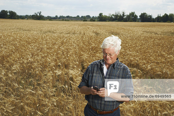 Farmer in Field with Electronic Organizer