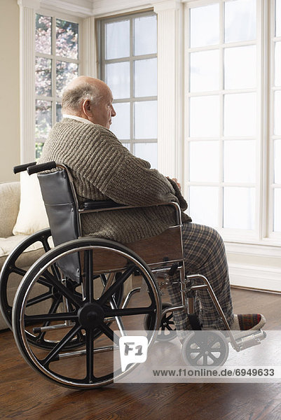 Senior Man in Wheelchair  Looking Out Window