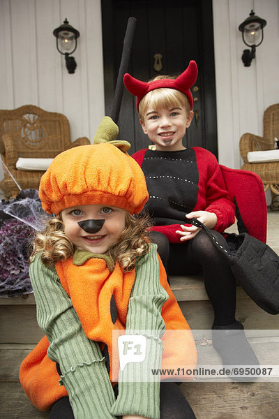 Portrait of Girl Dressed-up as Pumpkin and Boy Dressed-up as Devil