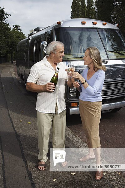 Couple Standing by Trailer  Celebrating With Champagne