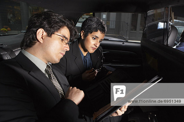 Business People Looking at Documents in Taxi  New York City  New York  USA