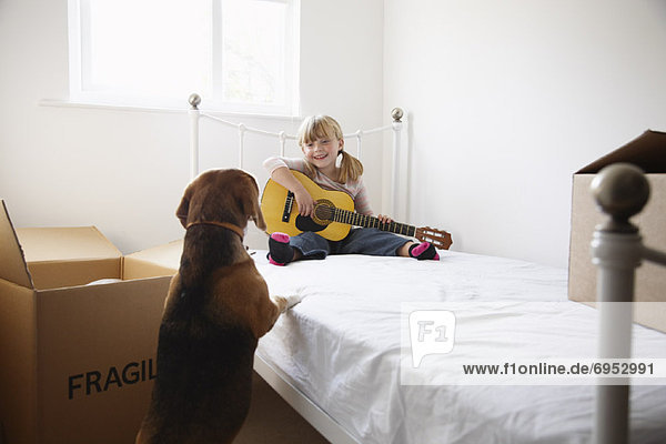 Girl with Guitar and Dog in Bedroom of New Home