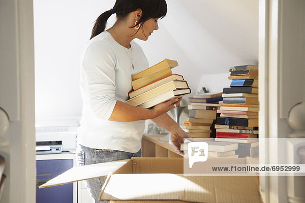 Woman Packing Books into Box