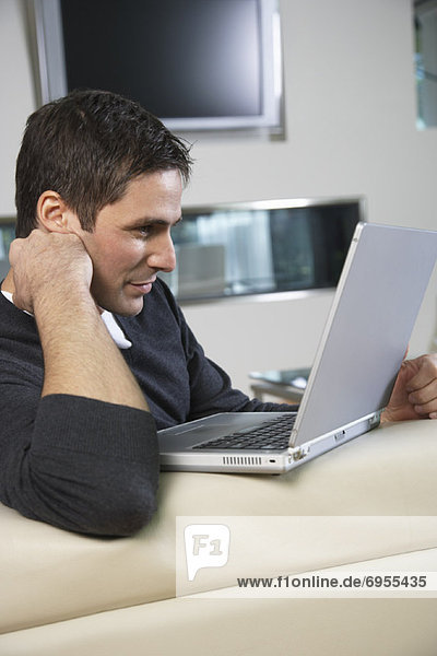 Man in Living Room with Laptop Computer