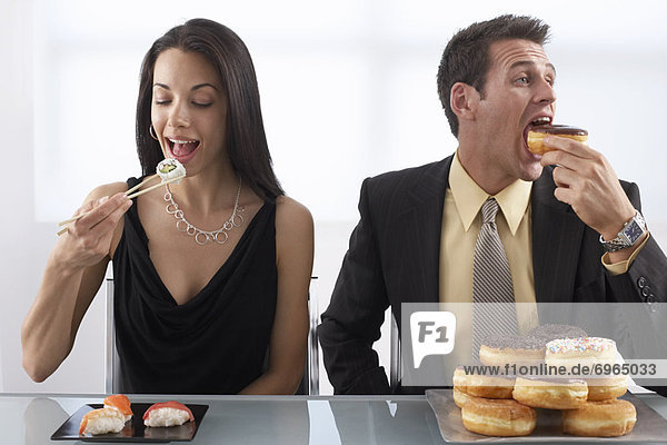Woman Eating Sushi and Man Eating Doughnuts