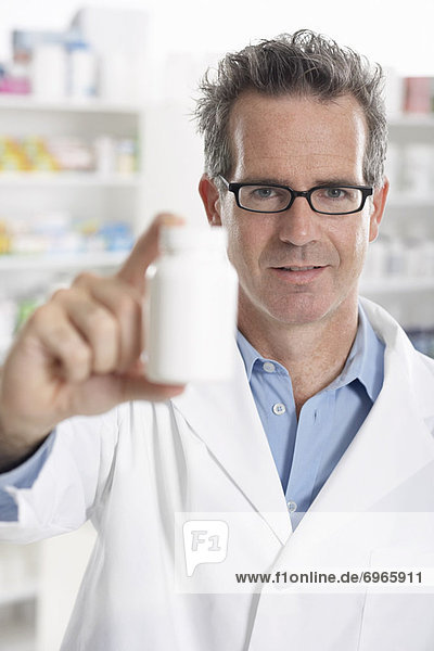 Portrait of Pharmacist Holding Bottle of Pills
