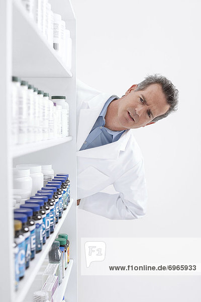 Pharmacist Looking at Pills on Shelf