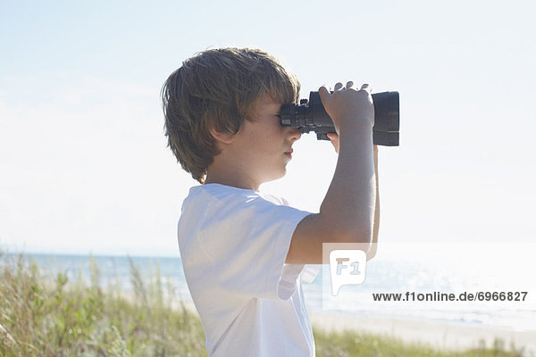 Boy on the Beach Looking Through Binoculars  Elmvale  Ontario  Canada