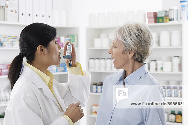 Pharmacist Showing Client How to Use Inhaler