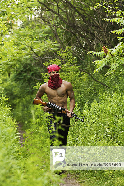 Man Walking on Forest Path  Carrying Gun