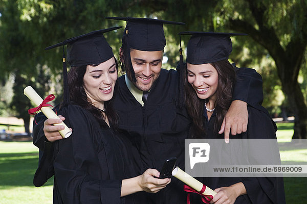 College Graduates Looking at Cellular Phone
