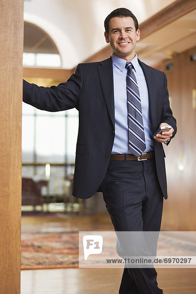 Portrait of Businessman in Office Holding an Electronic Organizer
