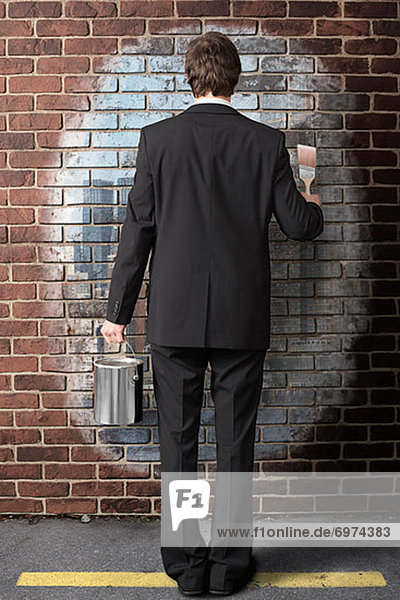 Businessman Painting on Brick Wall