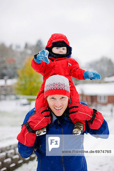 Little Boy Riding on Fathers Shoulders in Winter  Portland  Oregon  USA