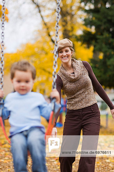 Mother Pushing Son on Swing in the Park  Portland  Oregon  USA